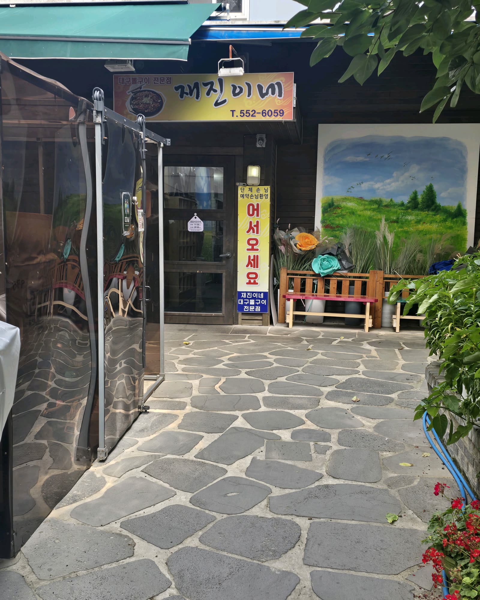 재진이네아구찜 동래본점 외관, 골목 안 재진이네 간판과 어서오세요 배너가 걸린 입구