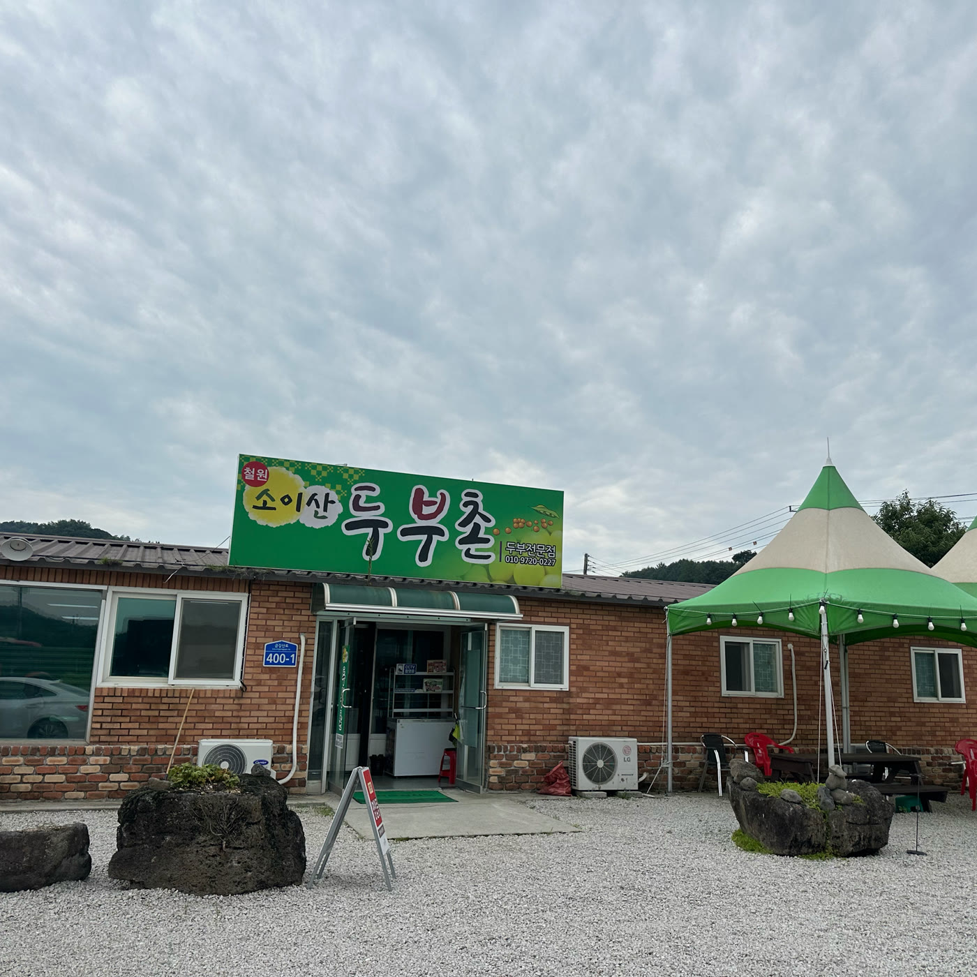 철원 소이산두부촌 외관, 초록 간판과 야외 정자, 넓은 주차장