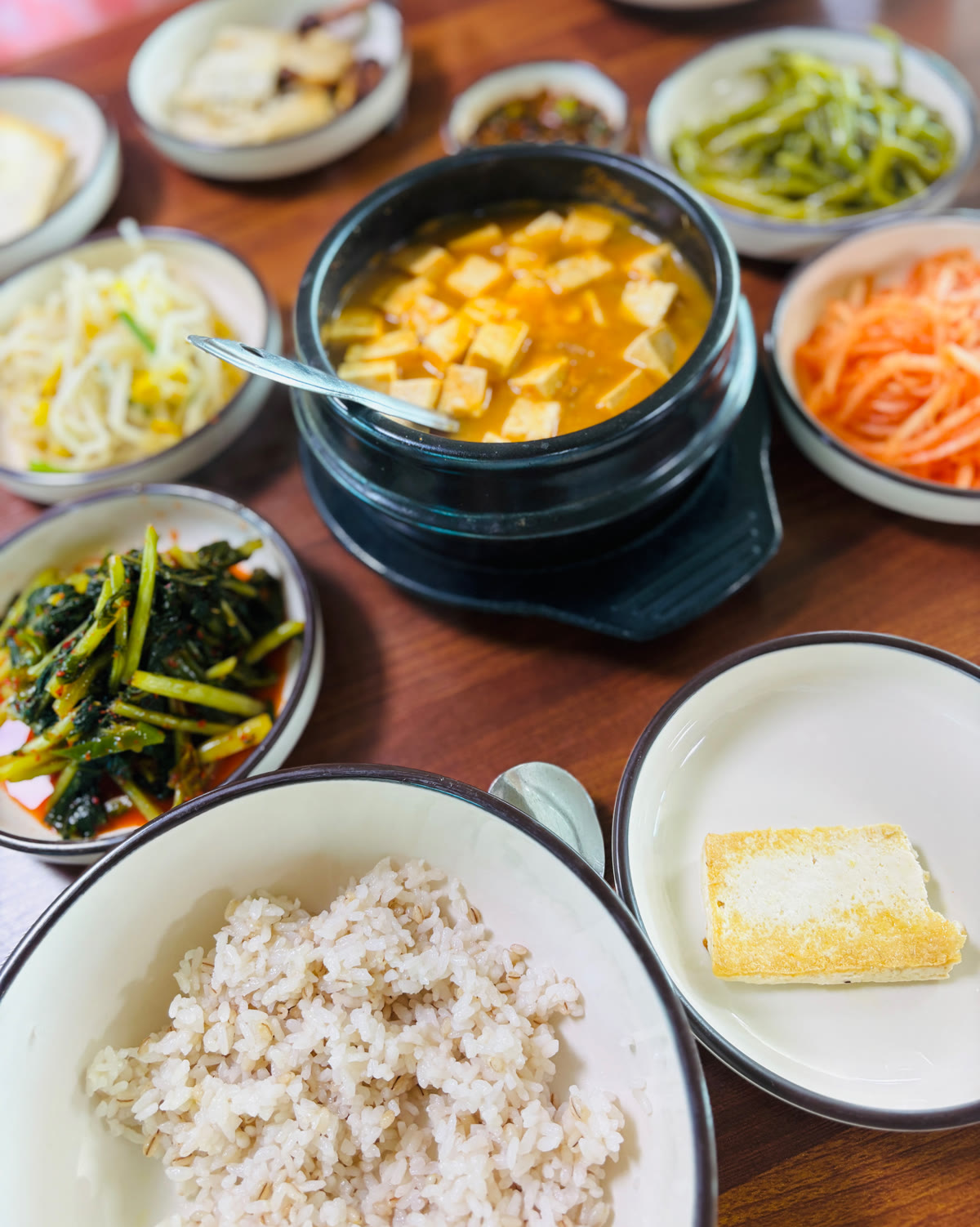 소이산두부촌 청국장 상차림, 보리밥과 나물 반찬, 두부구이가 함께 깔린 모습