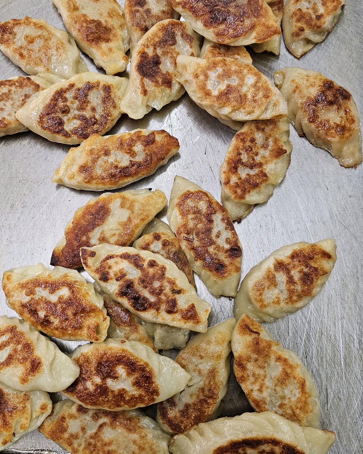 코끼리왕만두 야끼만두, 노릇하게 지져낸 군만두가 철판 위에 수북이 쌓인 모습
