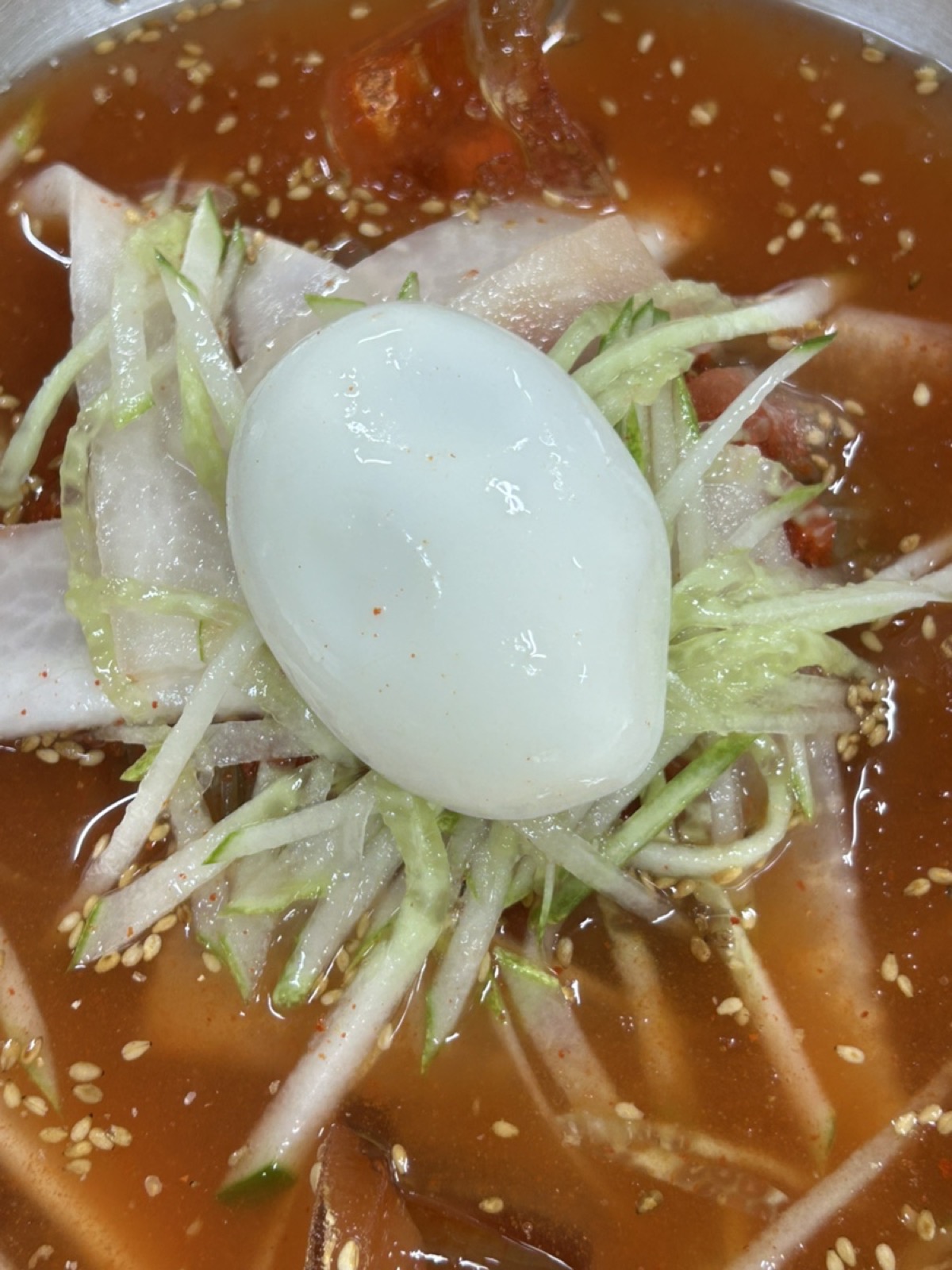 골목냉면 냉면 클로즈업, 면발과 고명 위로 육수가 자작하게 차오른 모습