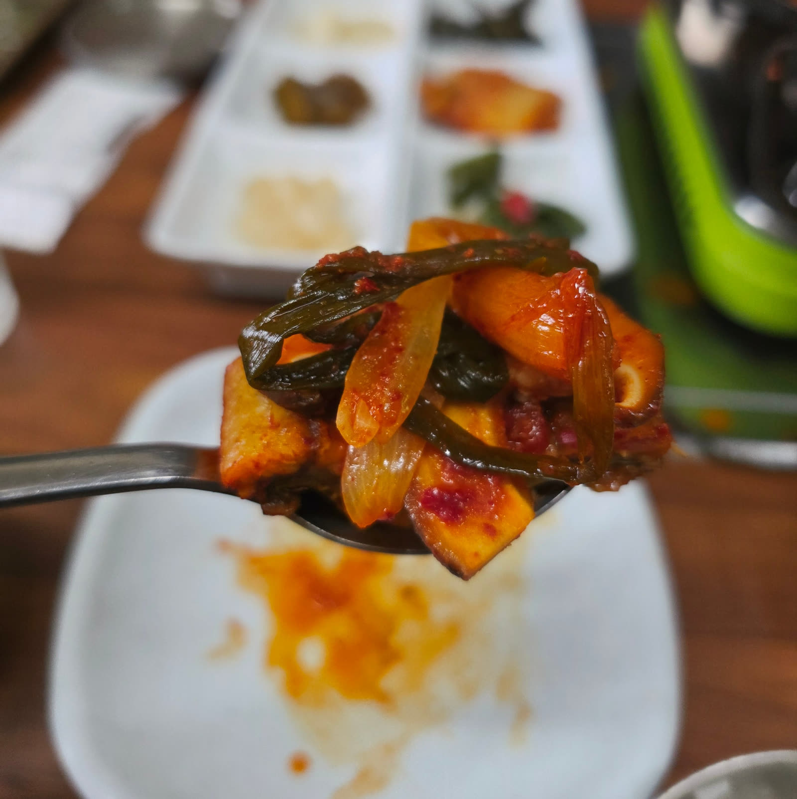 숟가락에 올린 파김치와 장어 한 점 클로즈업