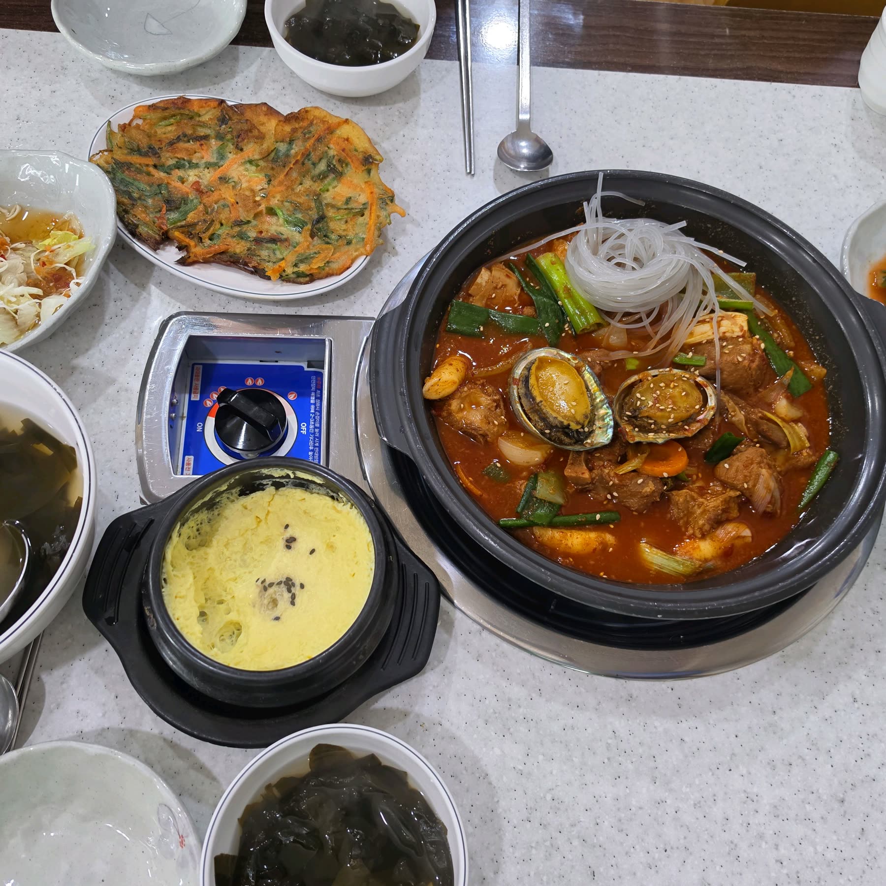청양골송아지매운갈비찜 기본 상차림, 계란찜과 부추전, 미역국이 함께 깔린 테이블
