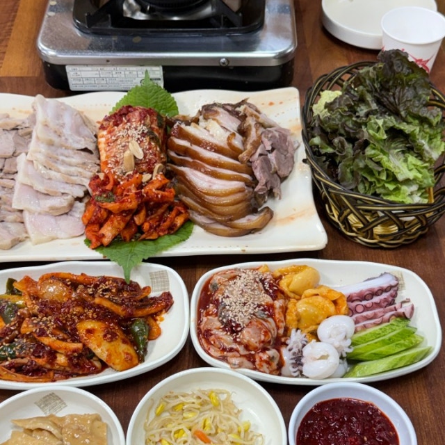 장군굴보쌈 스페셜모듬 세트 상차림, 보쌈과 굴무침 족발 접시에 낙지 문어 멍게 접시가 함께 차려진 모습