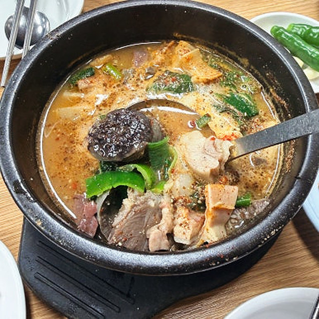 마포유가궁중족발 술국 뚝배기, 순대와 고기 우거지가 들어간 얼큰한 국물이 끓는 모습