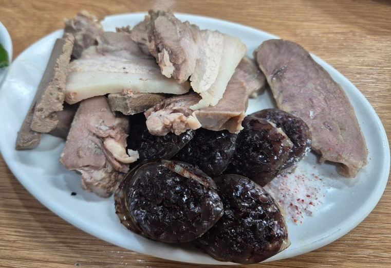 마포유가궁중족발 수육과 피순대 모둠 접시, 삶은 고기와 피순대가 소금과 함께 담긴 모습