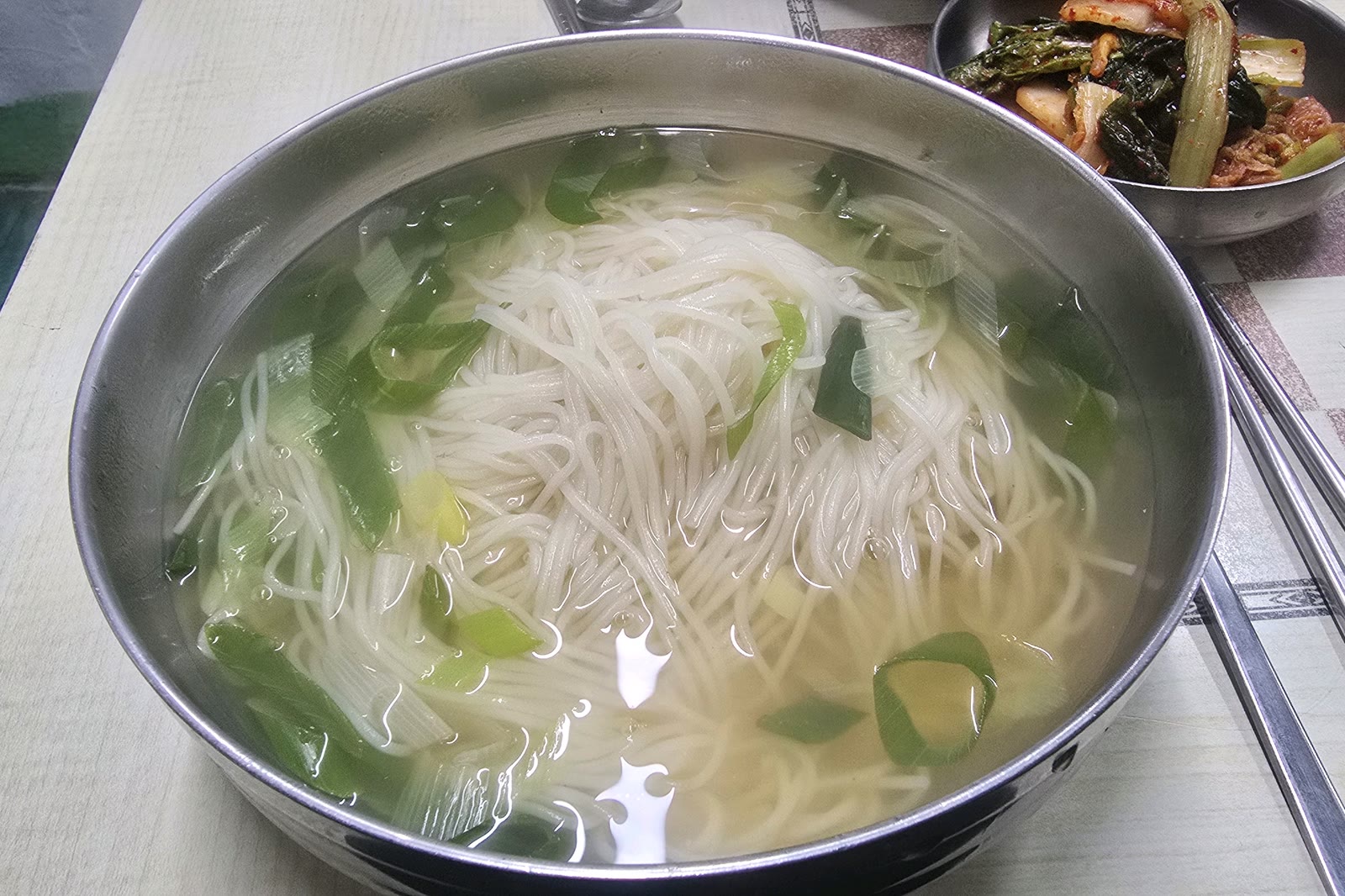 숭례분식 잔치국수, 맑은 멸치육수에 소면과 파가 담긴 스테인리스 대접