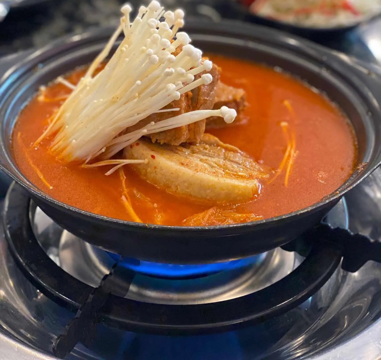 오산 엄마네 김치찜의 삼겹살 김치찜과 팽이버섯이 보글보글 끓는 모습