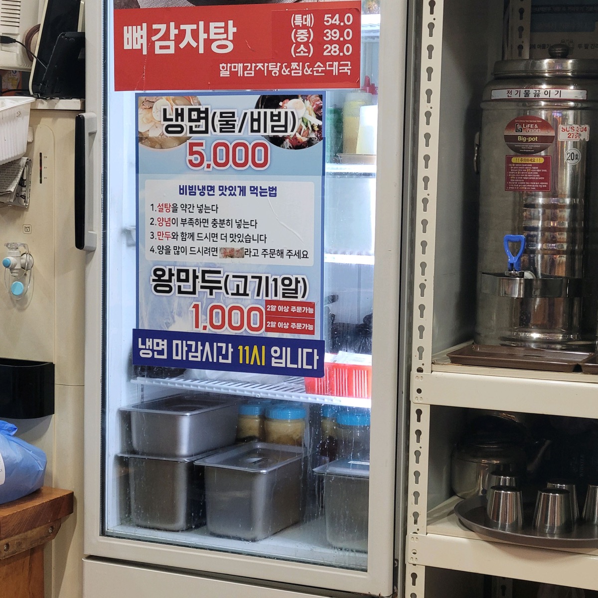 냉면 5,000원과 왕만두 1,000원 가격 안내판