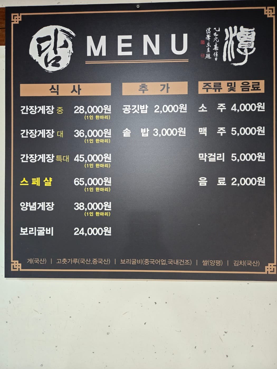 담 메뉴판, 간장게장 중 28,000원부터 보리굴비 24,000원까지 식사와 주류 가격이 적힌 검은 메뉴판