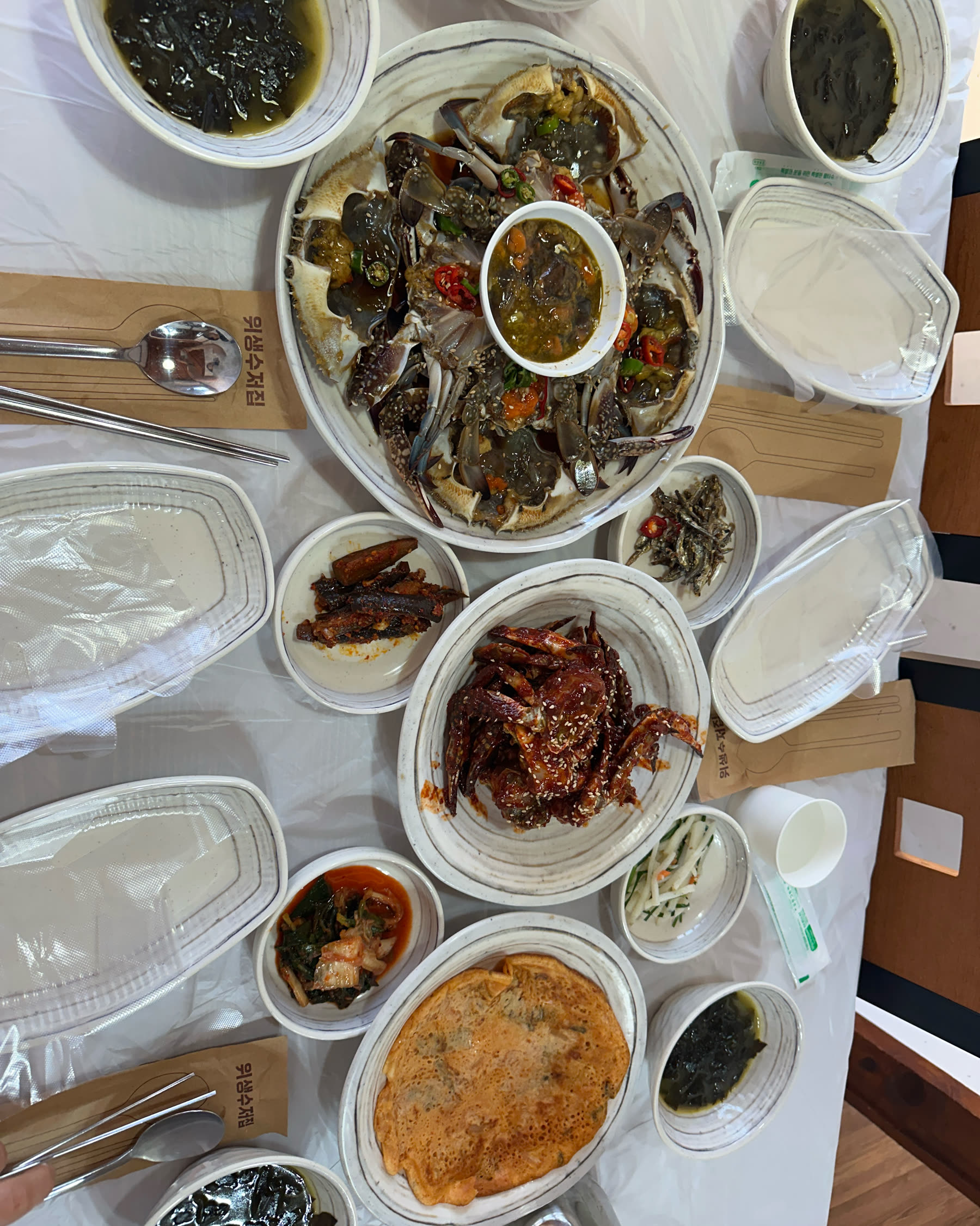 담 게장백반 상차림, 간장게장 플래터와 양념게장, 김치전, 미역국, 밑반찬이 한 상 가득 차려진 모습