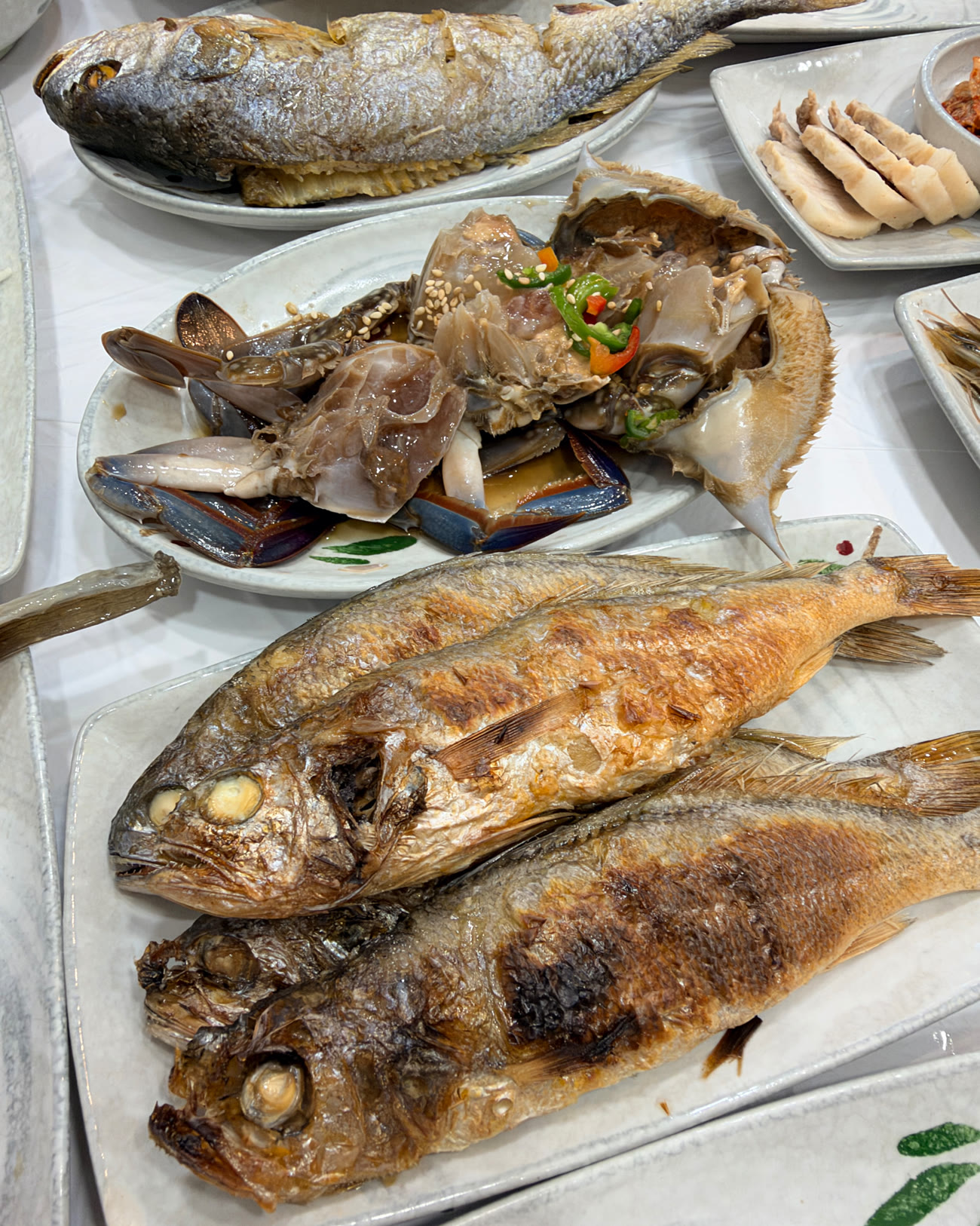 노릇하게 구운 조기구이 두 마리와 간장게장, 수육이 함께 차려진 상