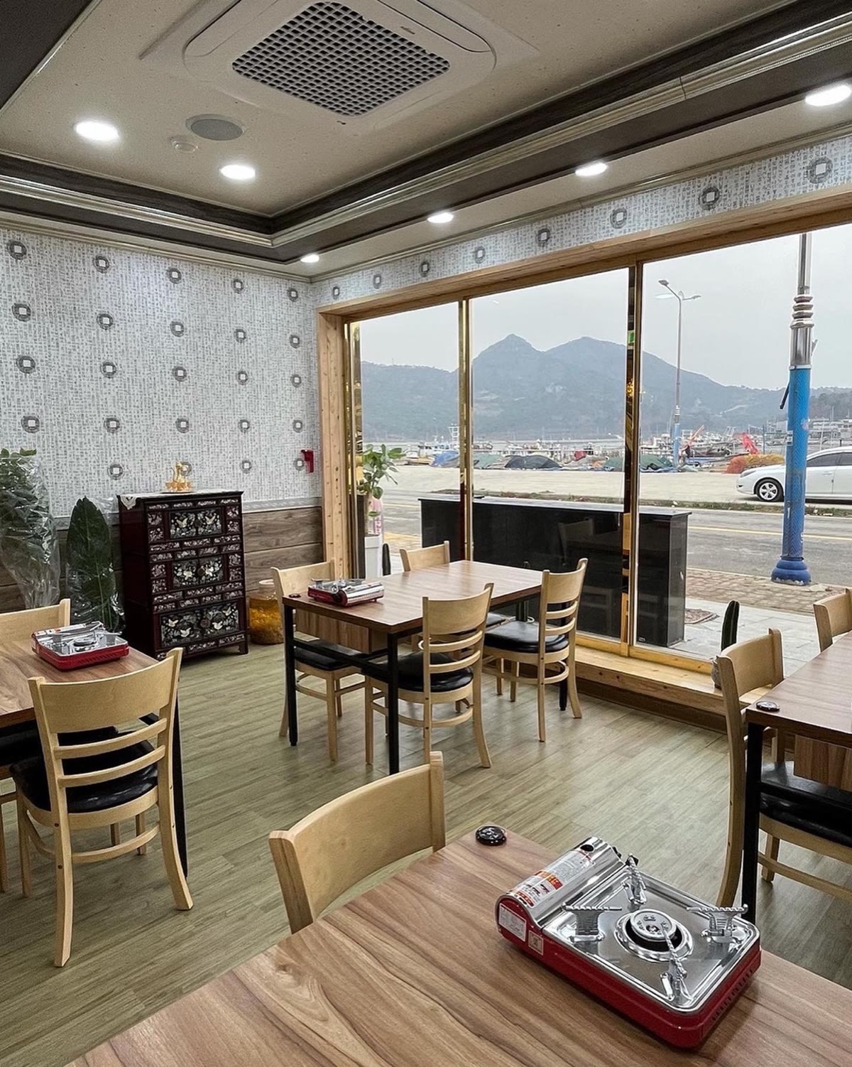 통창 너머로 법성포구와 산이 보이는 깔끔한 매장 내부