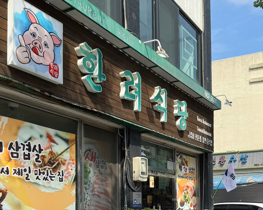 한려식당 초록 간판과 돼지 캐릭터 외관