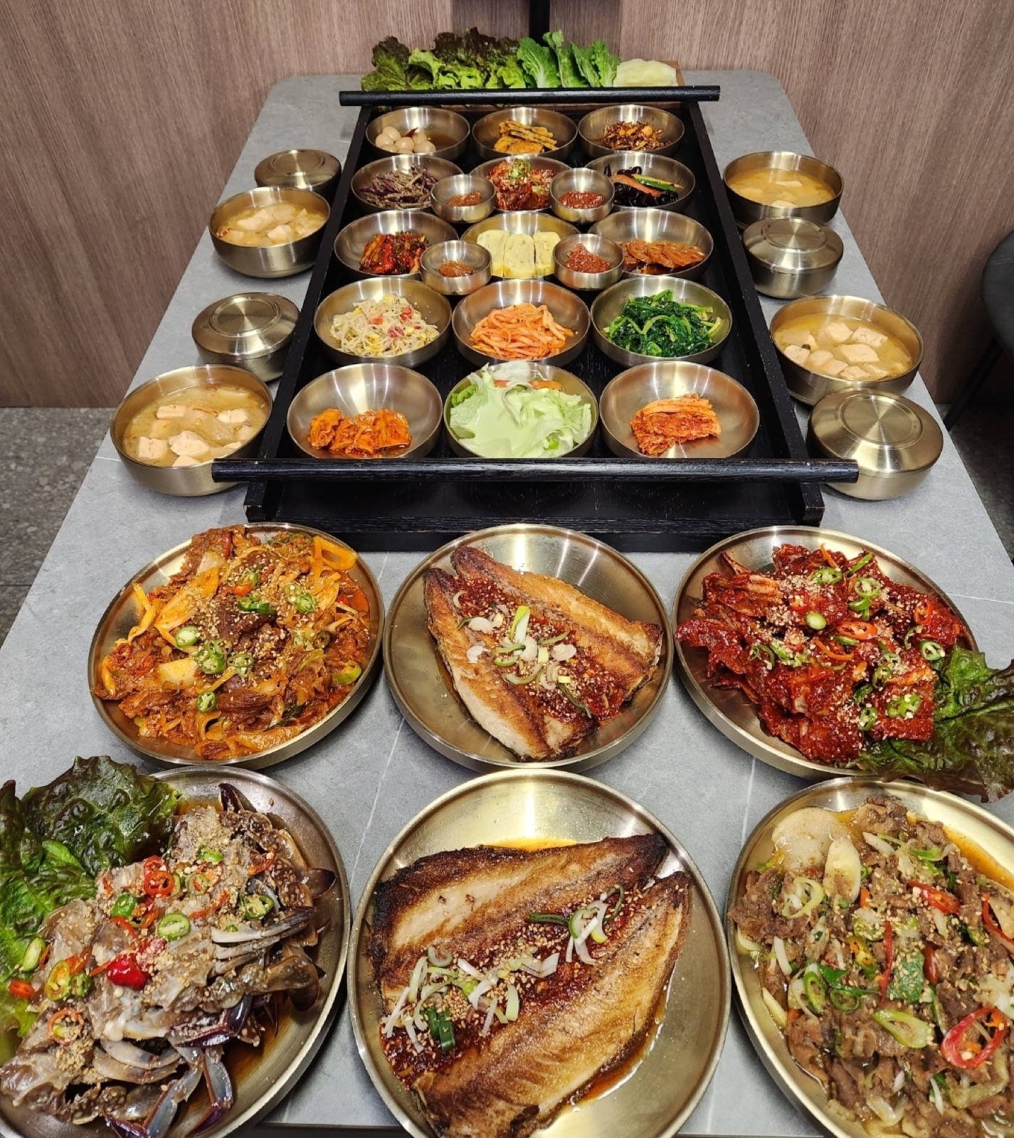 라도9900 프리미엄 백반 상차림, 반찬 트레이 앞으로 고등어구이와 게장, 제육 접시가 놓인 모습