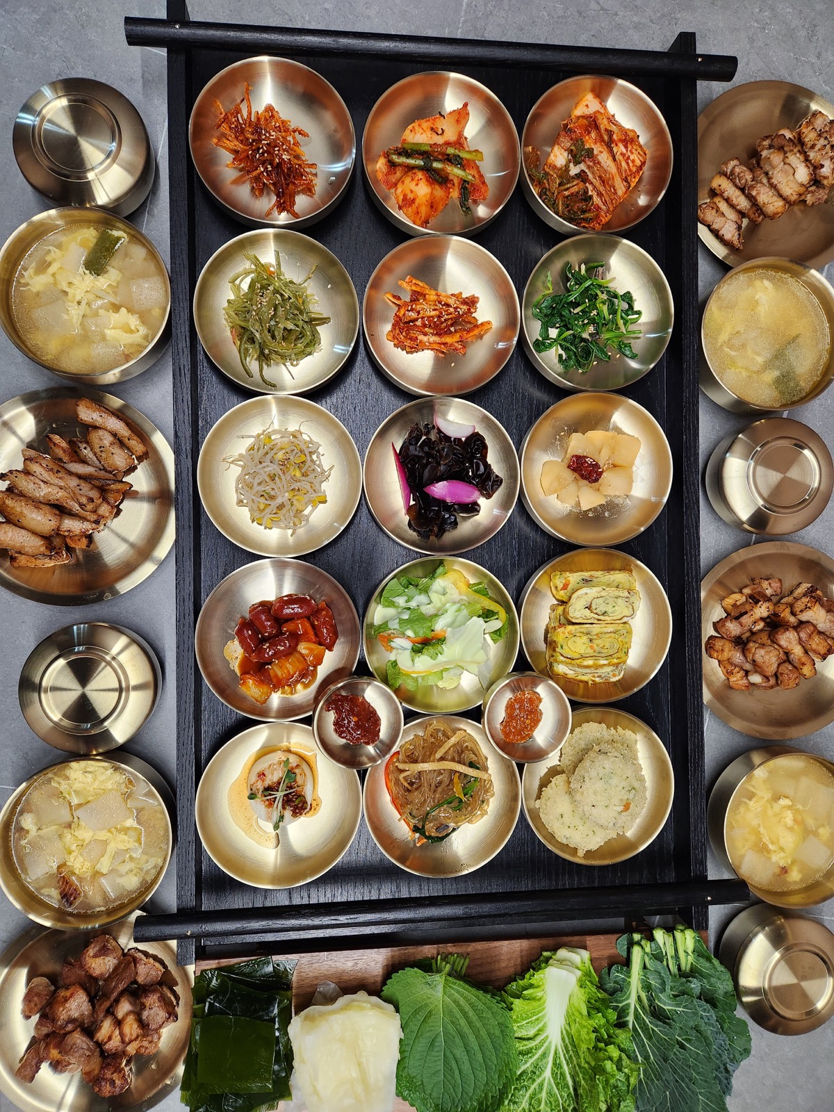 라도9900 반찬 트레이, 놋그릇에 담긴 15가지 반찬이 검은 트레이에 정갈하게 배열된 모습