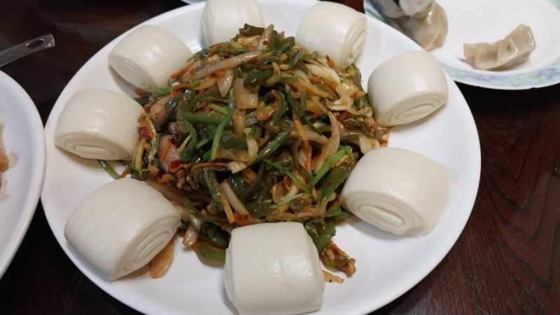 수원만두 고추잡채와 꽃빵, 피망과 고기채 볶음 둘레로 꽃빵이 둘러진 접시