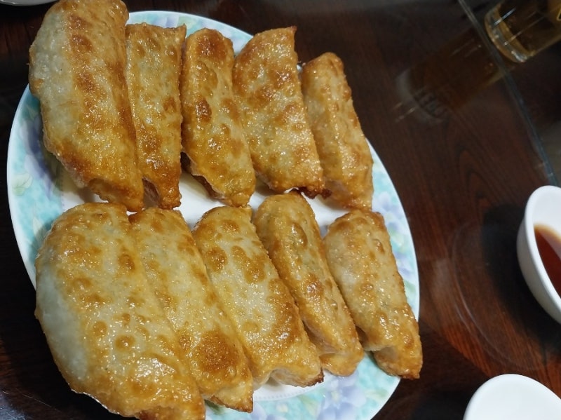 수원만두 군만두 한 접시, 노릇하게 구워진 군만두가 두 줄로 담긴 모습
