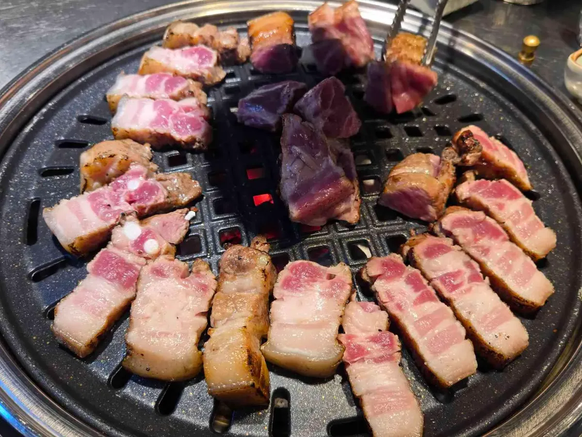 미숯랭의 흑돼지 오겹살을 불판에 올려 초벌로 구운 모습